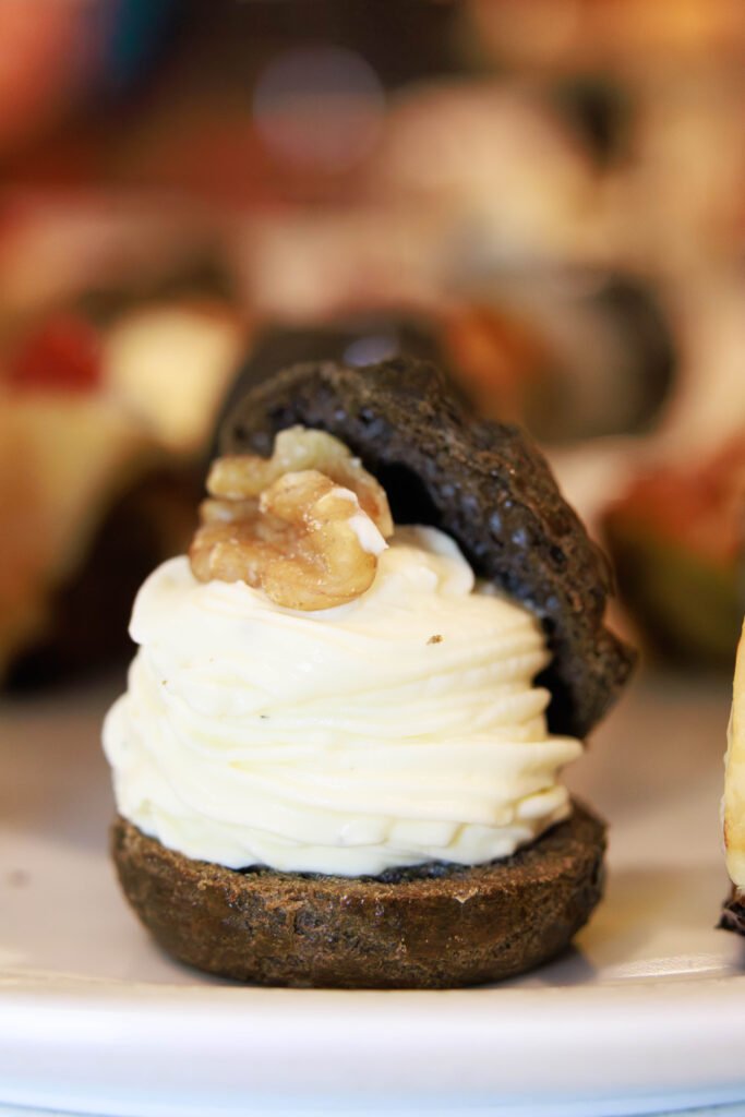 zoom in on our Black cocoa choux filled with goat cheese mousse and caramelized walnut praline